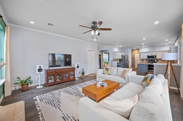 living room featuring dark hardwood / wood-style floors, ceiling fan, and ornamental molding