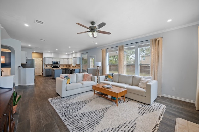 living room featuring ornamental molding, ceiling fan, and dark wood-type flooring