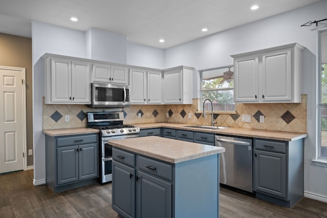 kitchen with a center island, stainless steel appliances, dark wood-type flooring, and sink