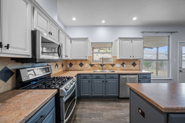 kitchen featuring white cabinetry, sink, tasteful backsplash, dark hardwood / wood-style flooring, and appliances with stainless steel finishes