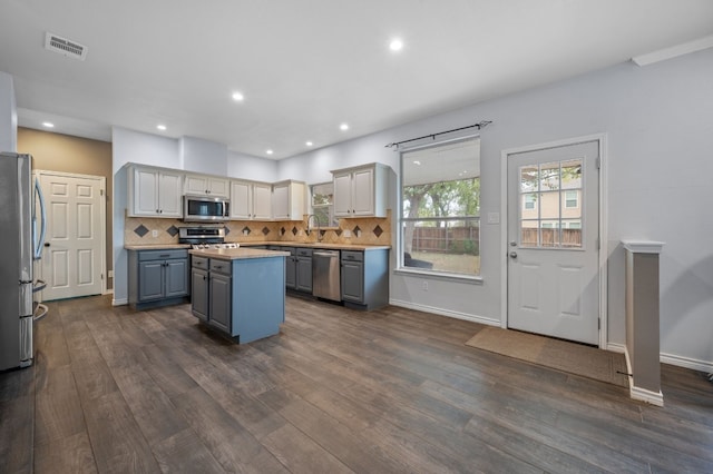 kitchen with a center island, sink, stainless steel appliances, and dark wood-type flooring