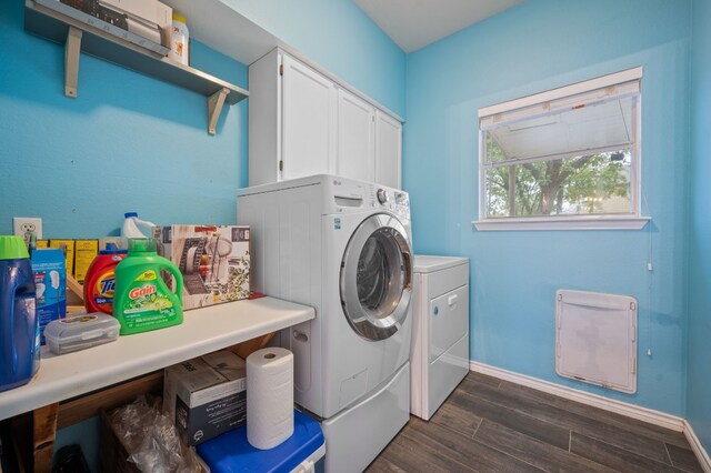 clothes washing area featuring cabinets, dark hardwood / wood-style flooring, and washer and dryer