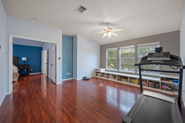 exercise room with dark hardwood / wood-style floors, vaulted ceiling, and ceiling fan