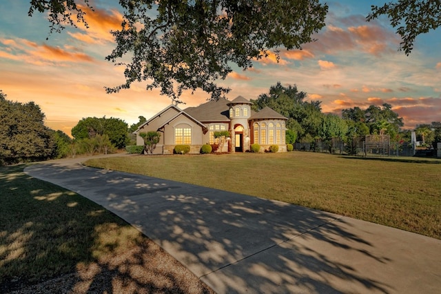 view of front facade with stucco siding, fence, and a front yard