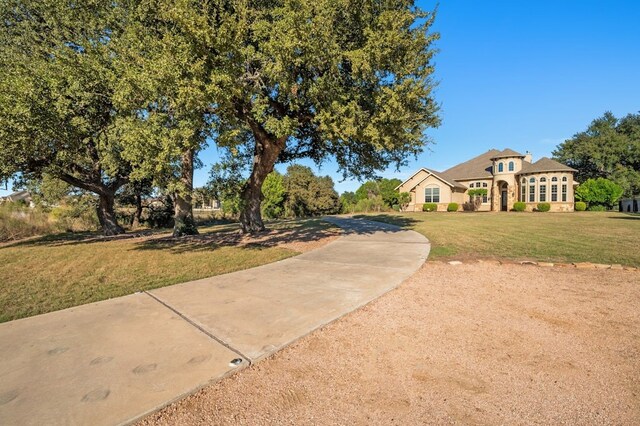 view of front of home with stucco siding, a front yard, and concrete driveway