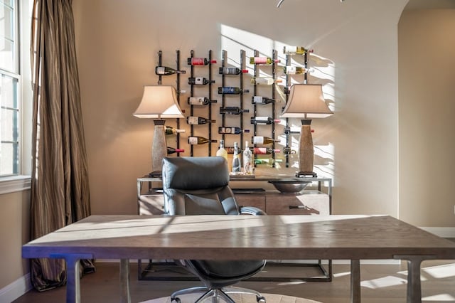 home office featuring arched walkways and baseboards