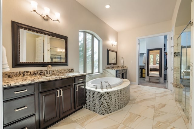 bathroom featuring shower with separate bathtub, vanity, and vaulted ceiling