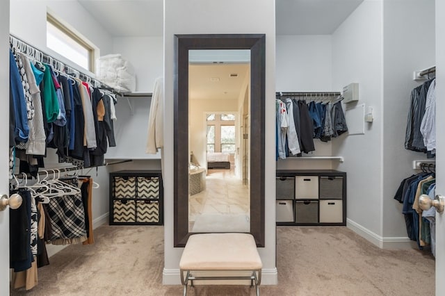 spacious closet featuring light colored carpet