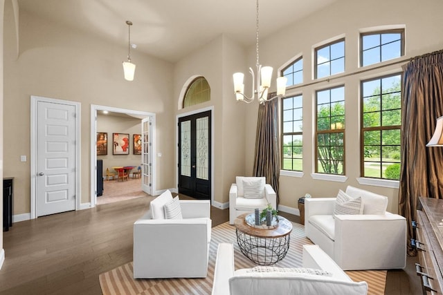 465 Linden Loop, Driftwood, TX 78619 - living room with french doors, healthy amount of natural light, hardwood / wood-style floors, a high ceiling, and a chandelier