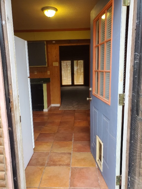 corridor with tile patterned flooring and wooden walls