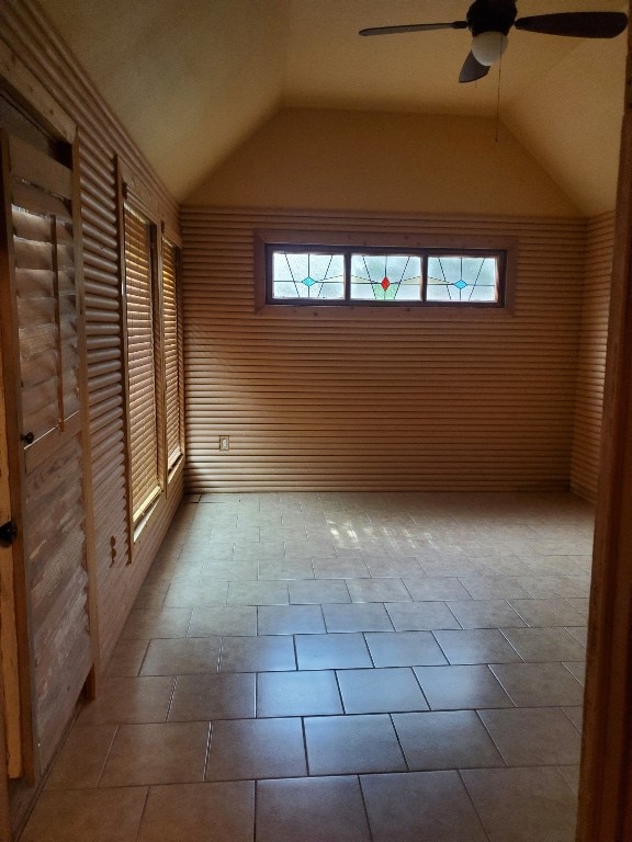 additional living space with ceiling fan, a healthy amount of sunlight, and vaulted ceiling