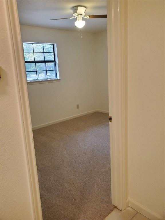 unfurnished room with carpet flooring and ceiling fan