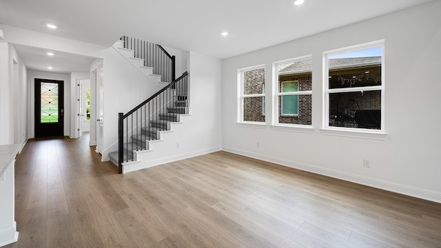foyer featuring stairs, wood finished floors, baseboards, and recessed lighting