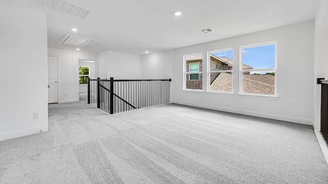 carpeted spare room featuring attic access, baseboards, and recessed lighting