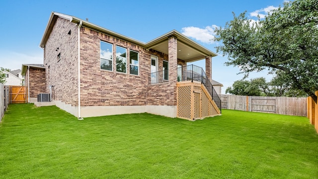 rear view of house featuring brick siding, cooling unit, and stairs