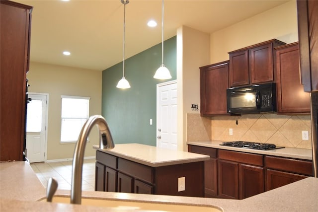 kitchen featuring a center island, stainless steel gas cooktop, backsplash, pendant lighting, and light tile patterned floors