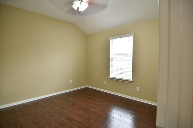 spare room with ceiling fan, dark wood-type flooring, and vaulted ceiling