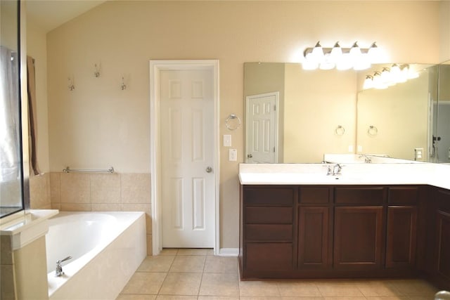 bathroom featuring vanity, tile patterned floors, and tiled tub