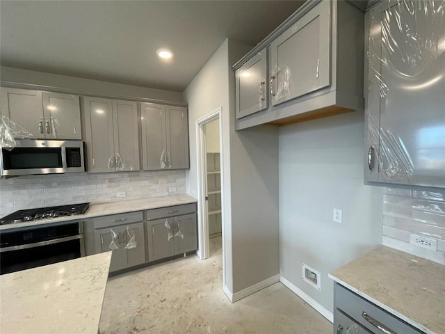 kitchen with backsplash, appliances with stainless steel finishes, and gray cabinetry