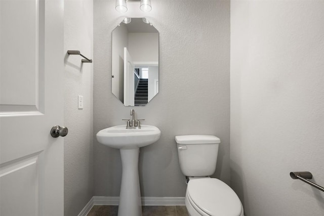 half bath with toilet and baseboards