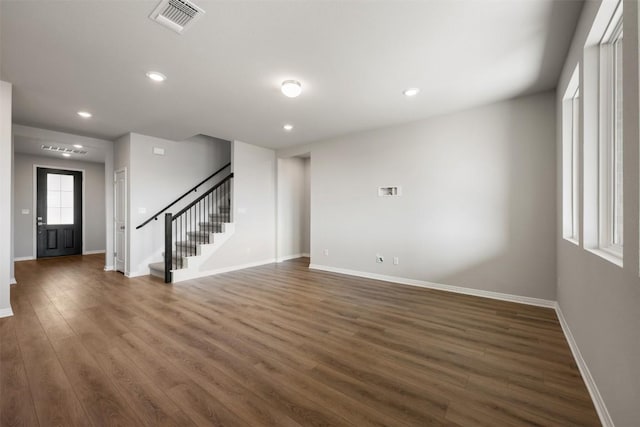 spare room featuring baseboards, visible vents, wood finished floors, stairs, and recessed lighting