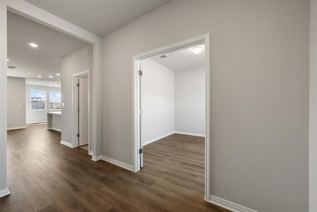 hallway featuring recessed lighting, visible vents, dark wood finished floors, and baseboards