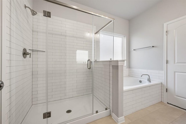 bathroom featuring tile patterned flooring, a shower stall, and a bath