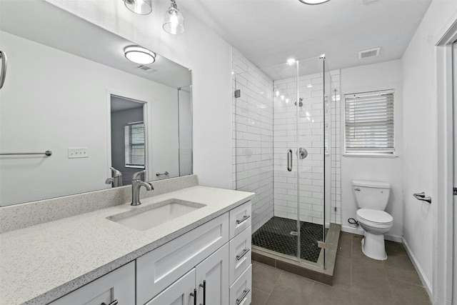 bathroom featuring tile patterned flooring, vanity, toilet, and walk in shower