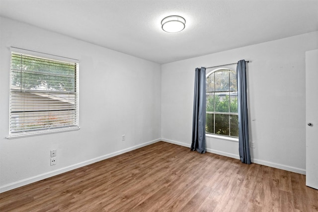 unfurnished room featuring hardwood / wood-style floors and a textured ceiling