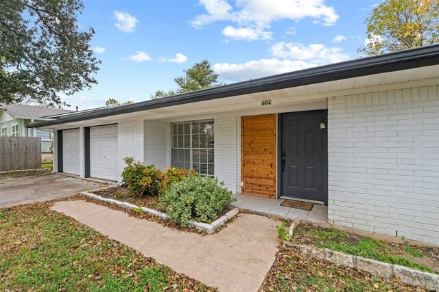 doorway to property with a porch and a garage