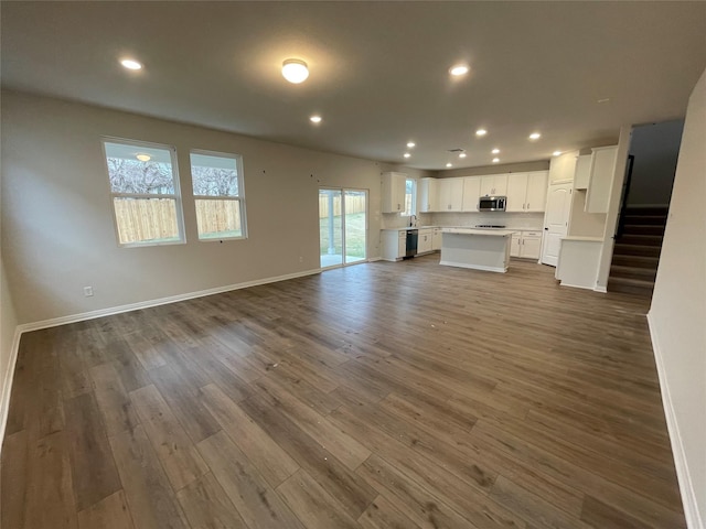 unfurnished living room with dark wood-type flooring and sink