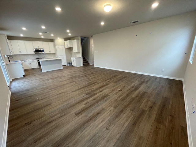 unfurnished living room featuring dark hardwood / wood-style flooring and sink