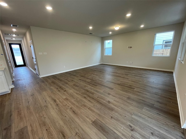 spare room with a wealth of natural light and hardwood / wood-style floors