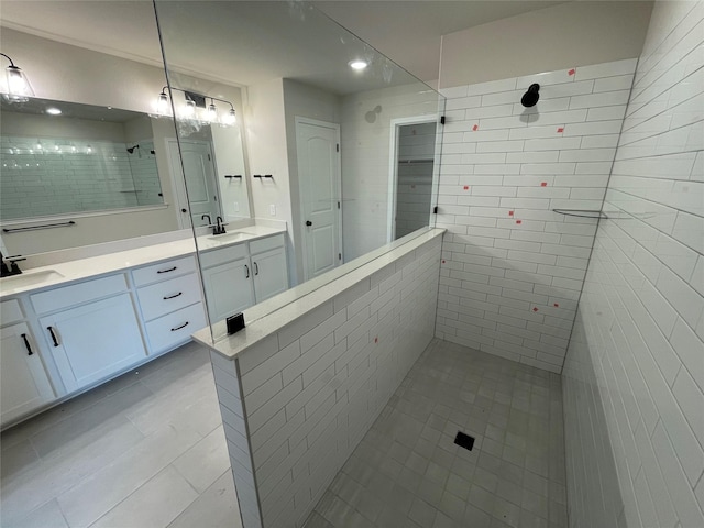 bathroom with tile patterned floors, tiled shower, and vanity