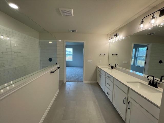 bathroom with vanity and a tile shower