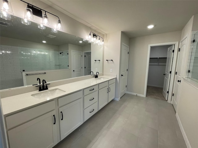 bathroom with vanity, tile patterned floors, and a tile shower