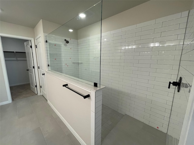 bathroom with tiled shower and tile patterned flooring