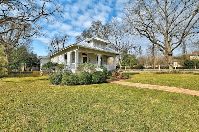 bungalow-style home with a porch, a front yard, and metal roof