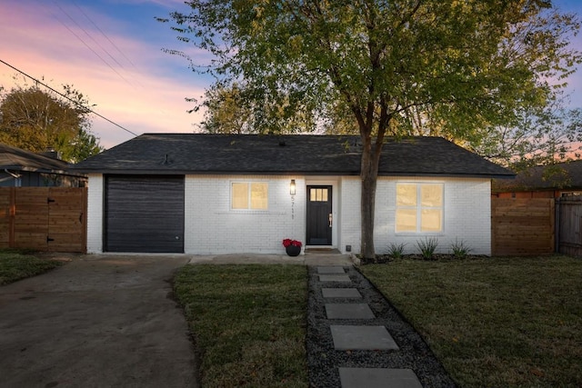 ranch-style home with a yard and a garage