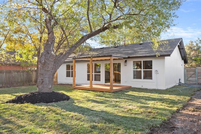 back of house with a deck and a yard