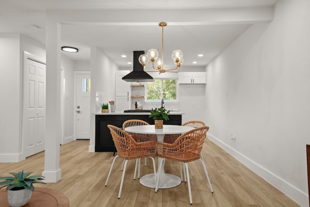 dining room with plenty of natural light, light wood-type flooring, and a chandelier