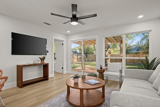 living room with light hardwood / wood-style floors and ceiling fan