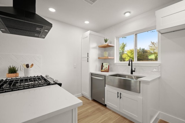 kitchen with tasteful backsplash, ventilation hood, stainless steel appliances, white cabinets, and light hardwood / wood-style floors