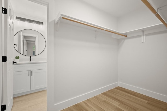 spacious closet with light hardwood / wood-style flooring