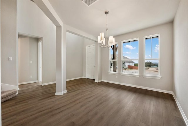 unfurnished dining area with dark hardwood / wood-style floors and an inviting chandelier