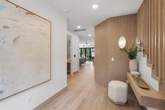 hall featuring wood walls and light hardwood / wood-style flooring