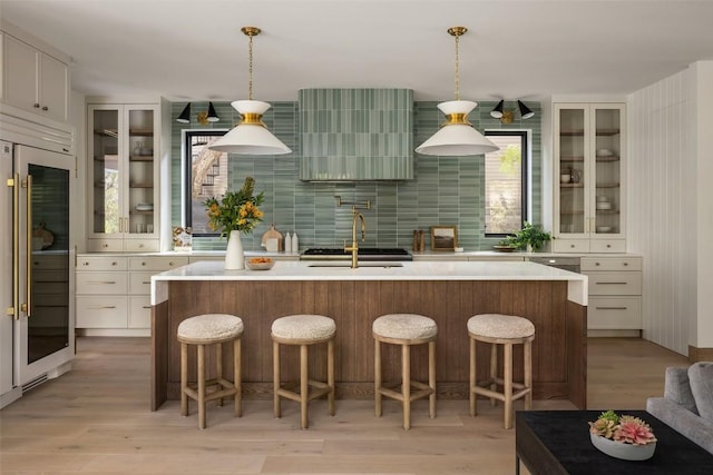 kitchen with white cabinetry, sink, tasteful backsplash, and hanging light fixtures