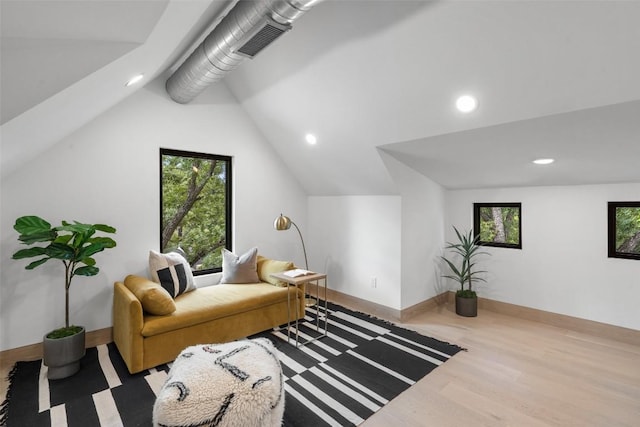 sitting room with wood-type flooring, lofted ceiling, and a wealth of natural light