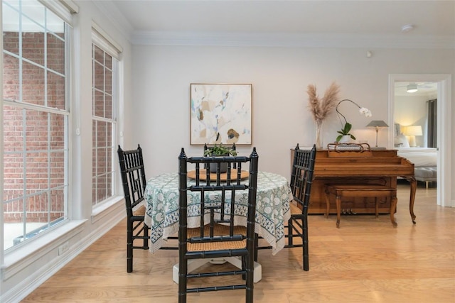 dining space featuring ornamental molding and light wood-type flooring