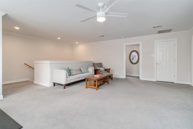 sitting room with ceiling fan, light colored carpet, and crown molding